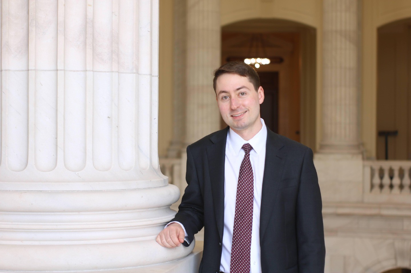 Ryan Nesselrodt poses for a photo next to a building column.