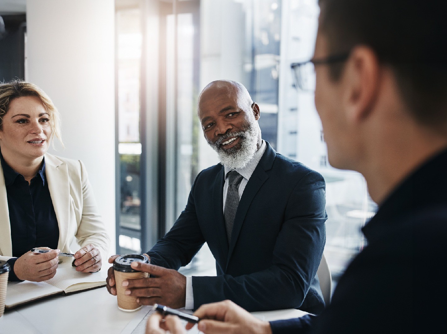 Three people in business suits sitting around a table
