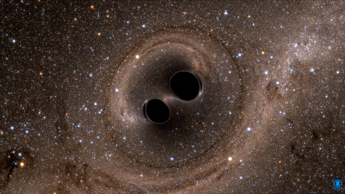 Two black holes hover close to one another, surrounded by starry space.
