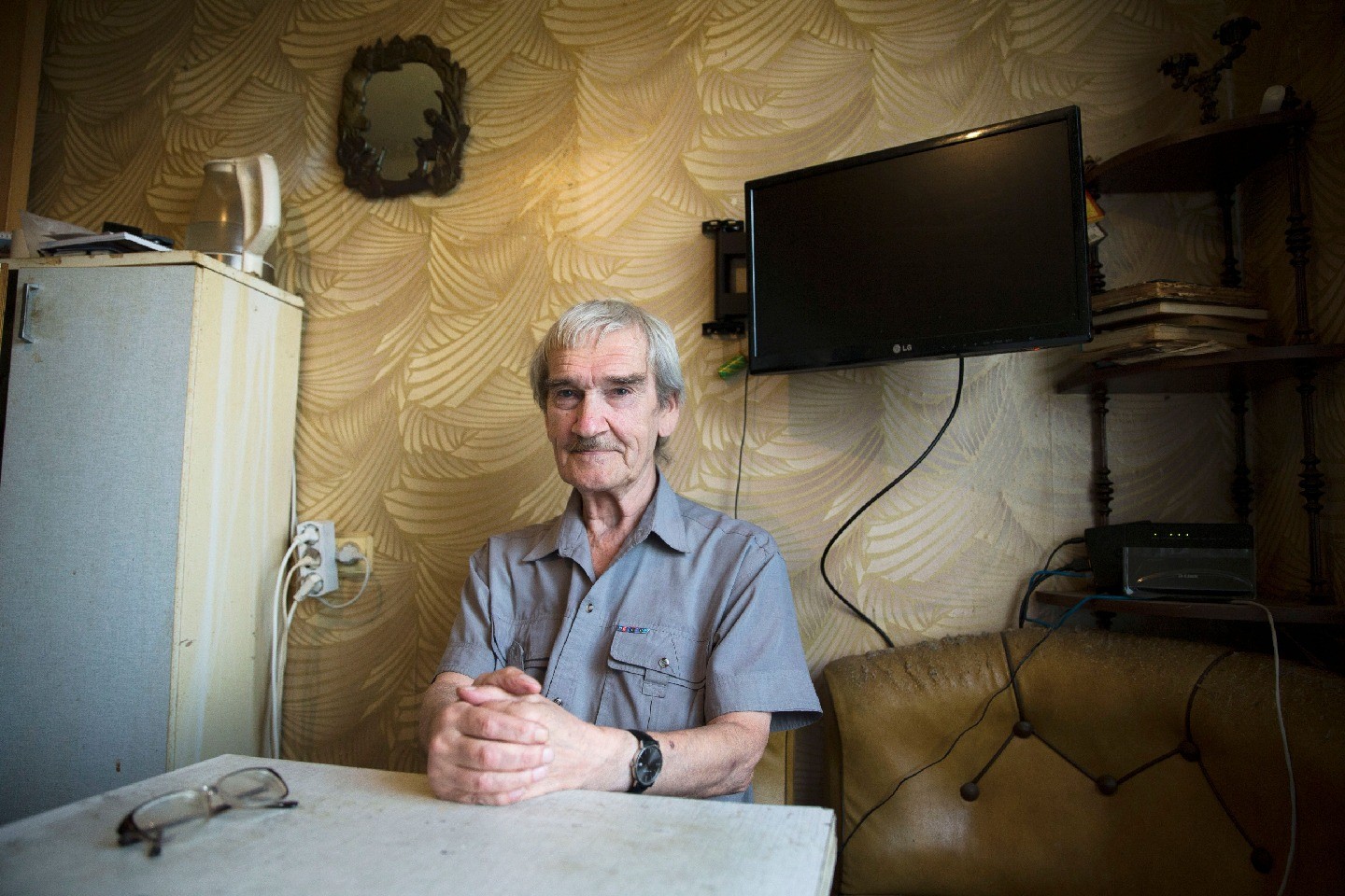 Stanislav Petrov is seated at a table in his home.