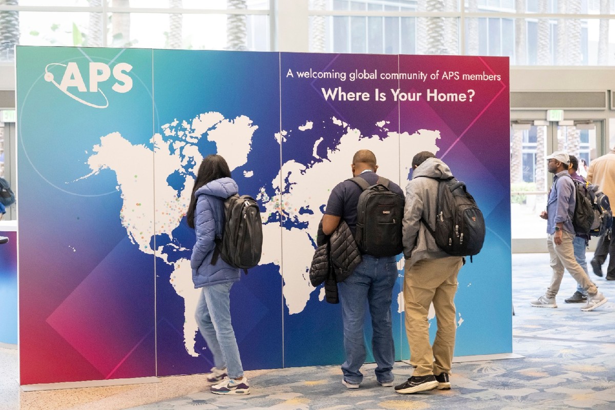 Students at the APS Global Physics Summit looking at a world map