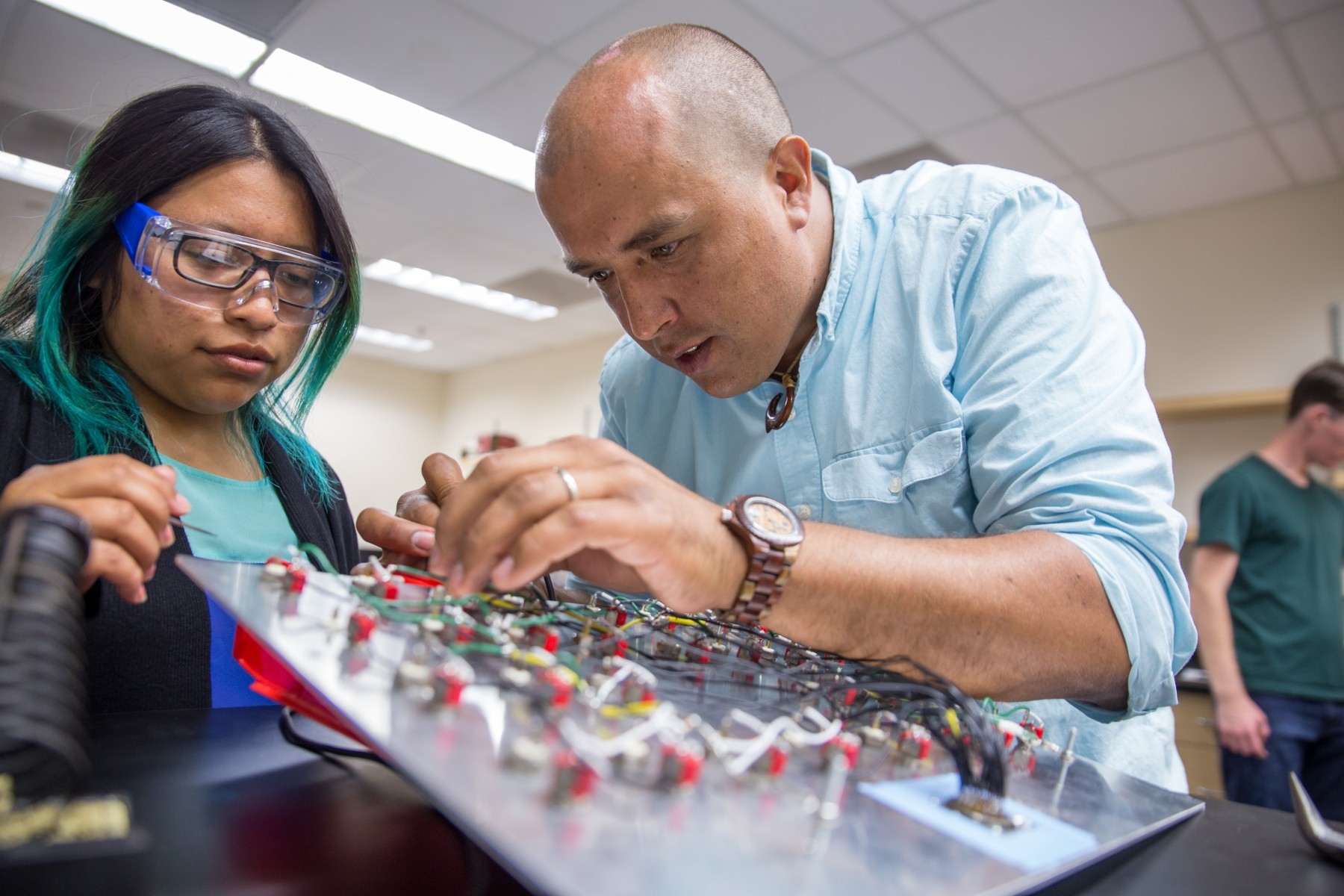 a physics professor works with a student