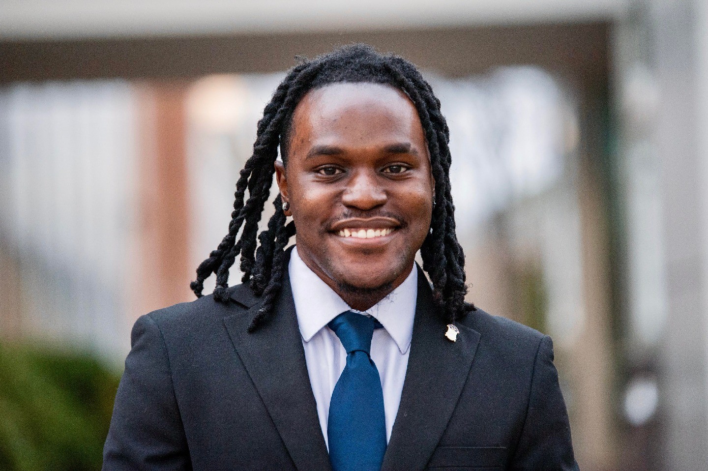 A headshot of Davion Huggins smiling at the camera.