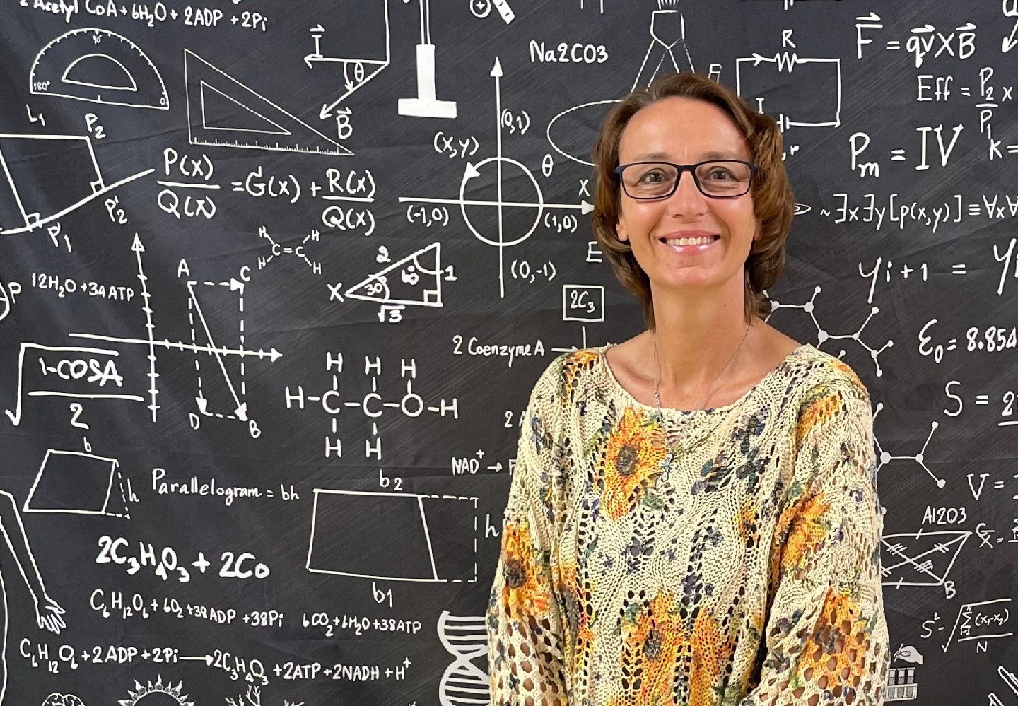 A headshot of Deborah Armstrong with the wall behind her is covered in scientific equations.