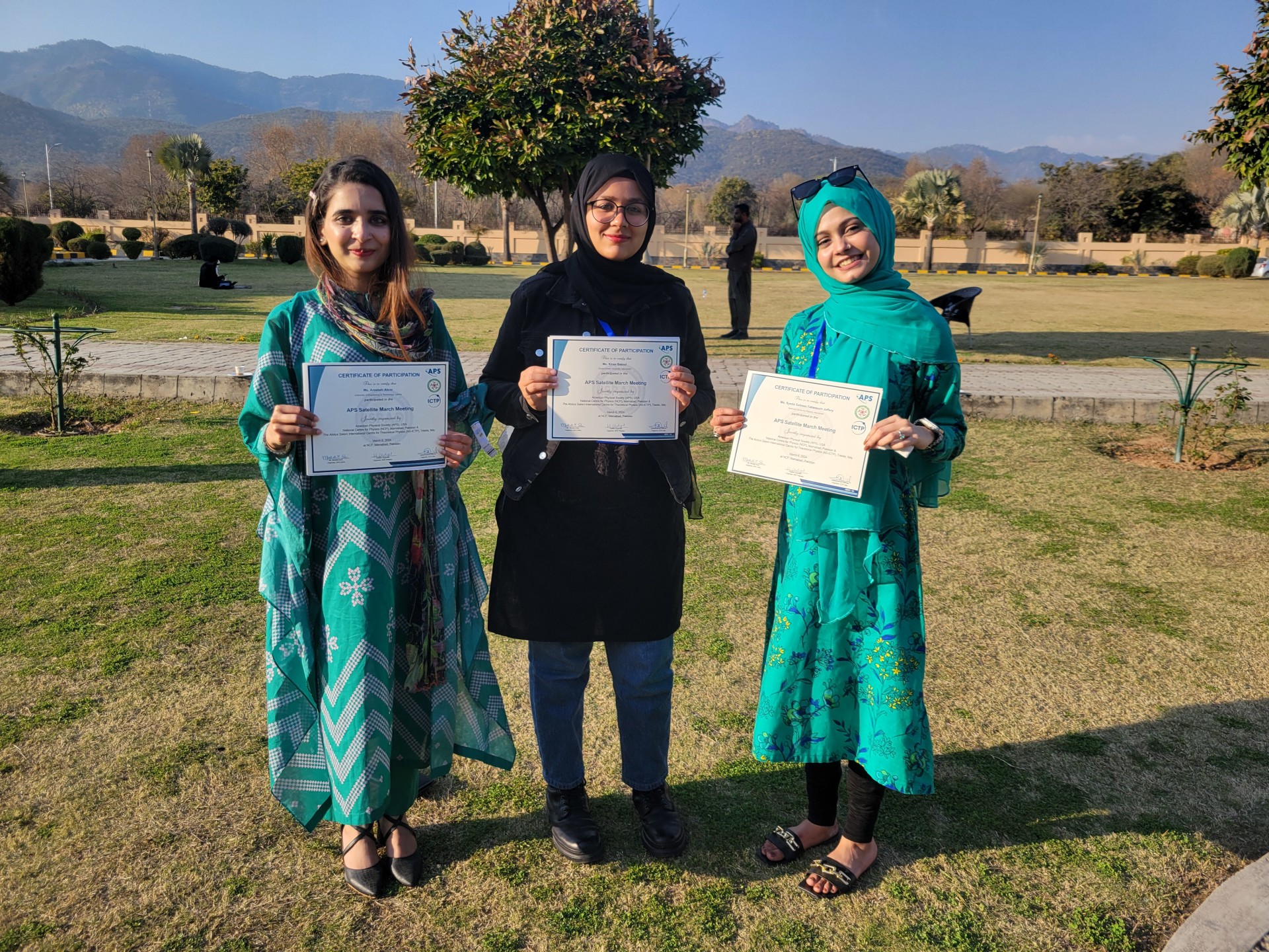 Three women hold a certificate