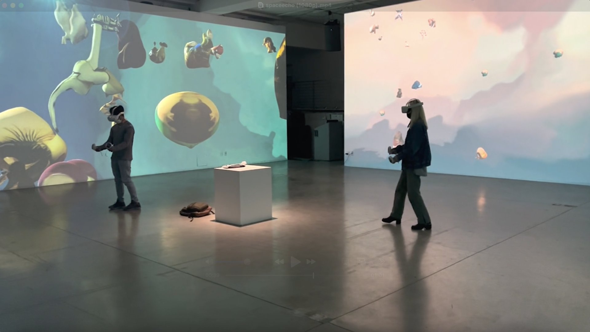 Two visitors in an art gallery wear VR headsets