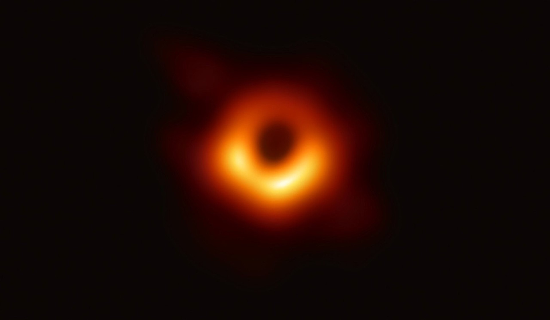 A fuzzy, asymmetric ring of glowing orange-yellow light