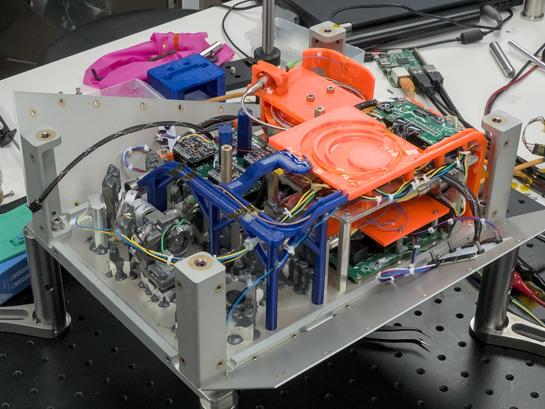 A close-up of the boxy interior of SEAQUE reveals colorful 3D-printed components (blue, orange), circuit boards, wiring, and other hardware.