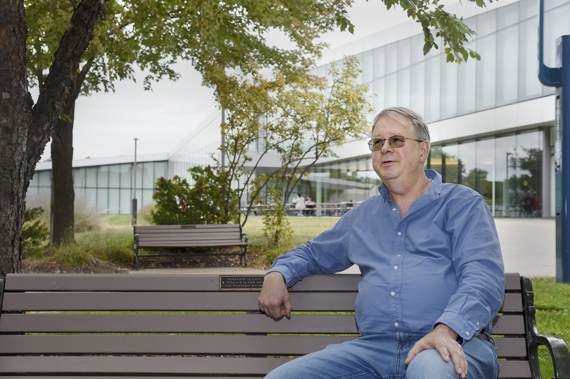 Cyrus Taylor seated on a bench outside.