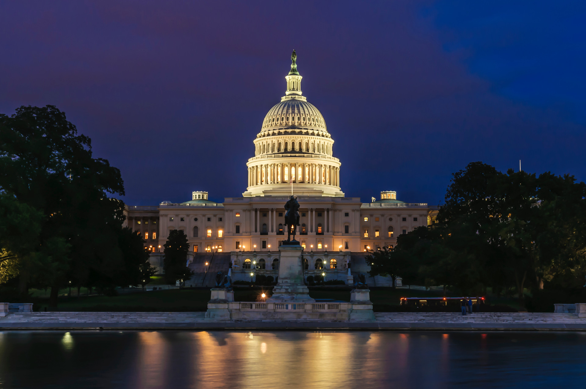 The U.S. Capitol building, illuminated by floodlights at night.